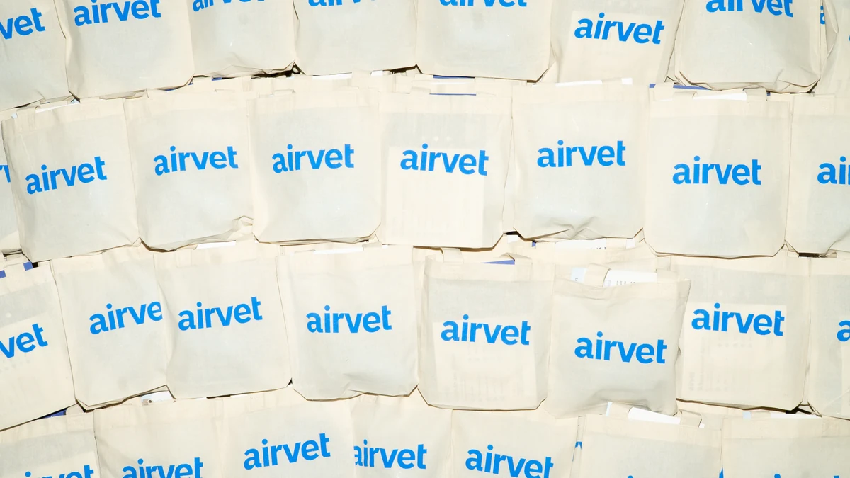 Natural canvas Airvet tote bags arranged together, with vivid blue printing.