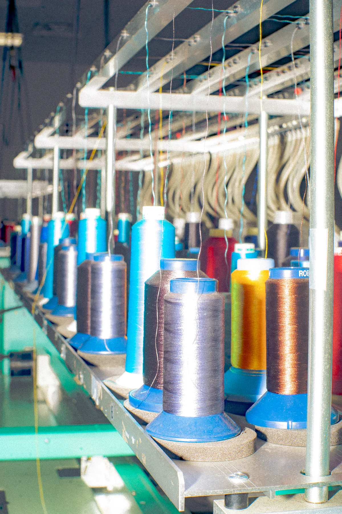 Thread-feed detail. Editorial illustration of embroidery / thread supply.